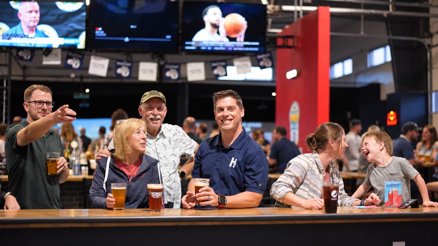 A busy Hitters bar with guests of all ages gathered along the counter