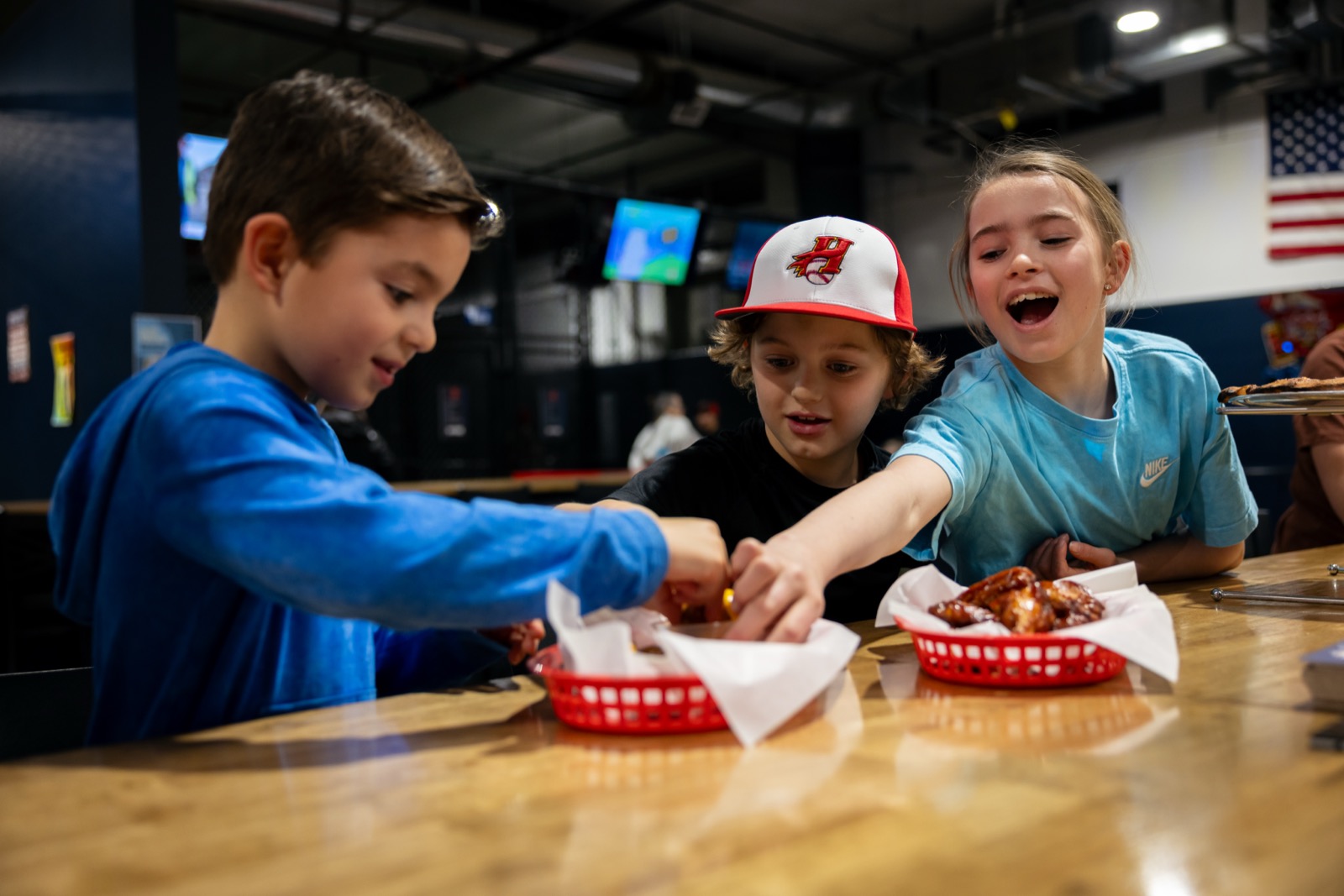 Kids laughing together over food at Hitters